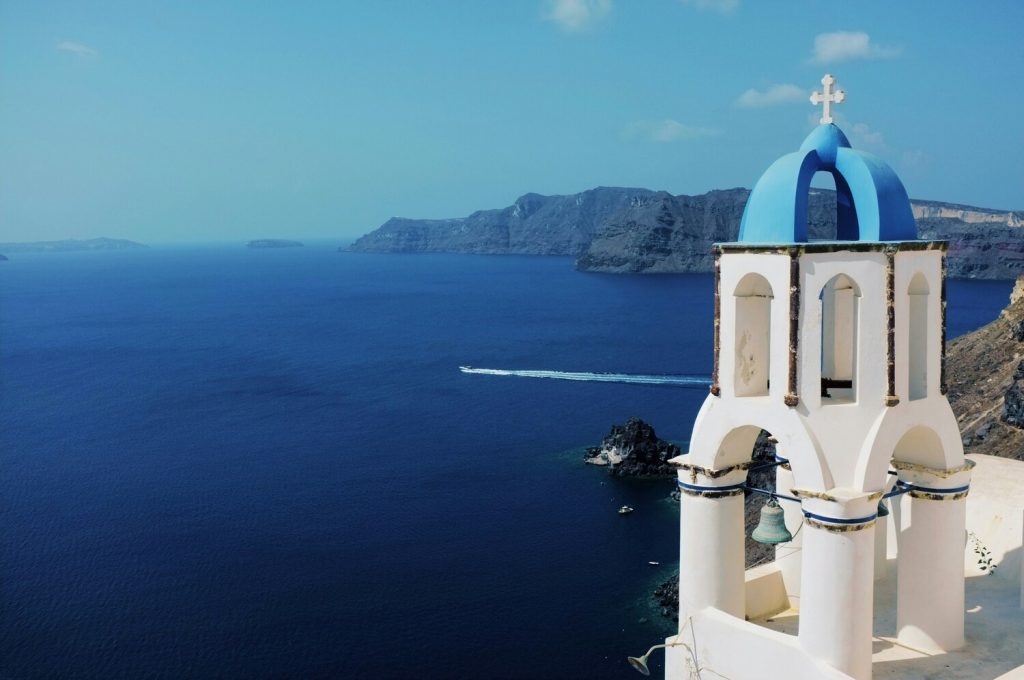 Santorin - Une chapelle bleue et blanche surplombant la mer aux couleurs azures